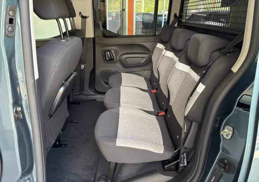 Vue latérale intérieure du Citroën Berlingo Kiama blue 2026 montrant les trois sièges arrière indépendants et la grille de séparation.