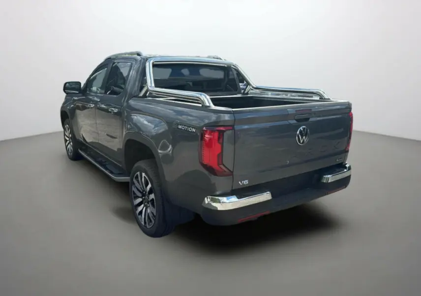 Volkswagen Amarok V6 240 BVA Aventura gris foncé vu 3/4 arrière droit avec barre chromée sur benne ouverte