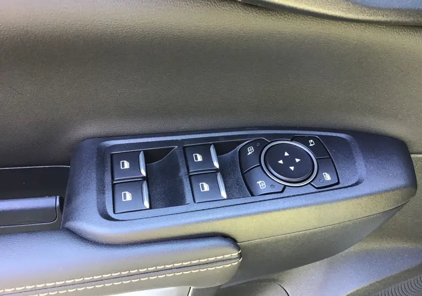 Panneau de commandes des vitres et rétroviseurs sur la porte côté gauche du Ford Ranger Double Cabine gris carbone 2025.