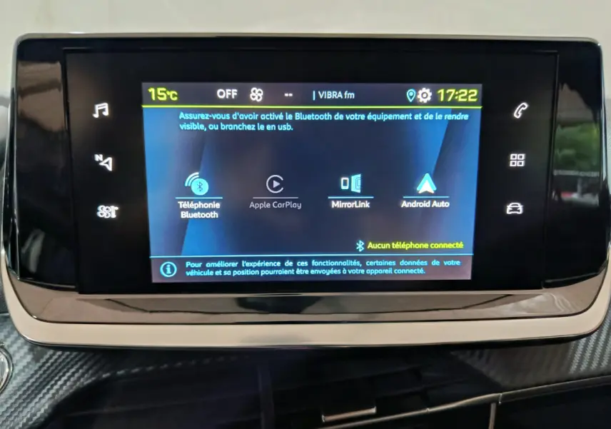 Écran tactile central allumé de la Peugeot 208 électrique 2023, affichant les options Bluetooth et Apple CarPlay.
