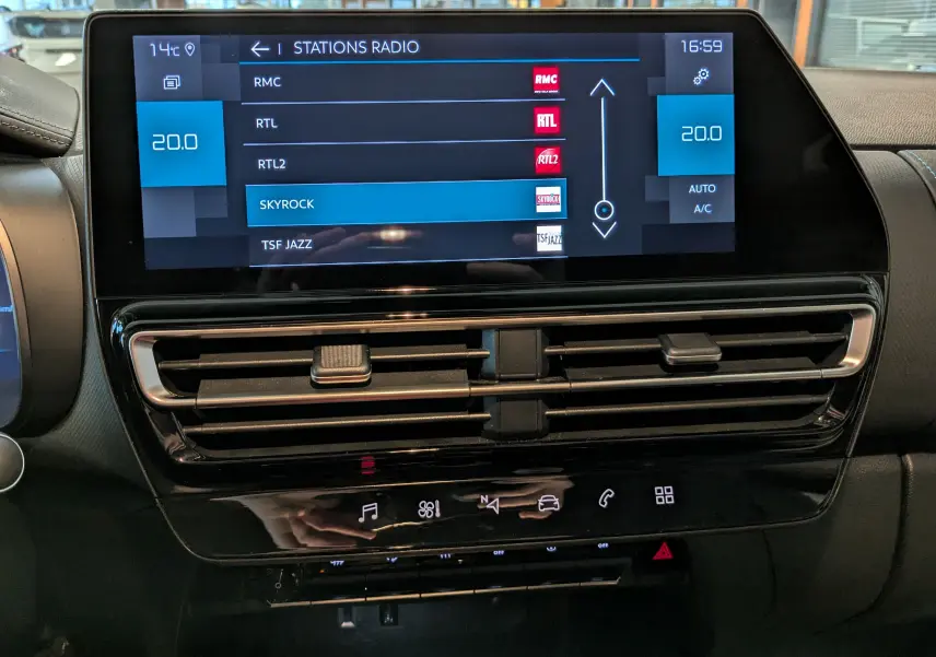 Tableau de bord du Citroën C5 Aircross hybride 2025, écran tactile affichant stations radio et commandes climatisation.