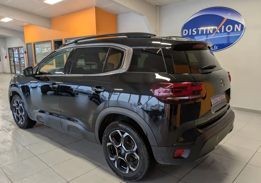 Vue 3/4 arrière droite d'un Citroën C5 Aircross hybride noir avec jantes alliage 18'' biton et vitres arrière surteintées.