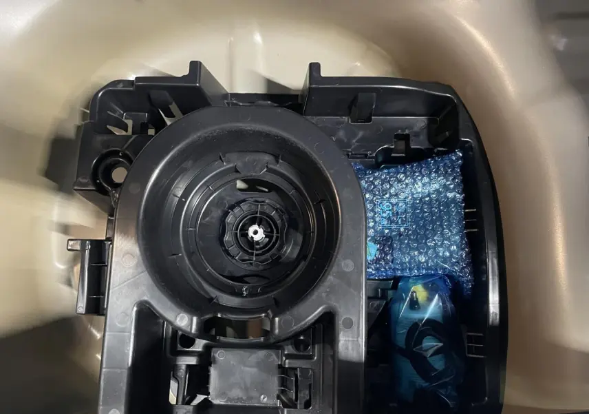 Vue rapprochée de la roue de secours et du rangement dans le coffre beige clair d'une Citroën C3 2024.