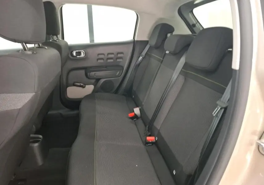 Vue intérieure côté droit de la banquette arrière noire avec surpiqûres jaunes d'une Citroën C3 beige clair 2024.