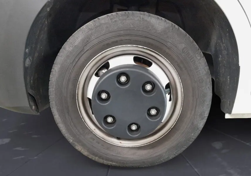 Gros plan sur la roue avant droite du Renault Master blanc 2024 avec jante acier et cache central noir.