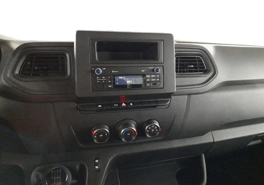 Vue rapprochée du tableau de bord noir du Renault Master 2024, avec commandes de climatisation et radio intégrée.
