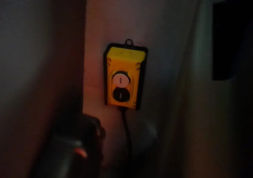 Vue intérieure sombre du boîtier de commande jaune fixé dans la cabine du Renault Master blanc 2024 version benne.