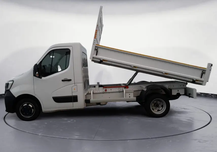 Renault Master blanc vue de profil gauche avec benne arrière relevée sur fond neutre.