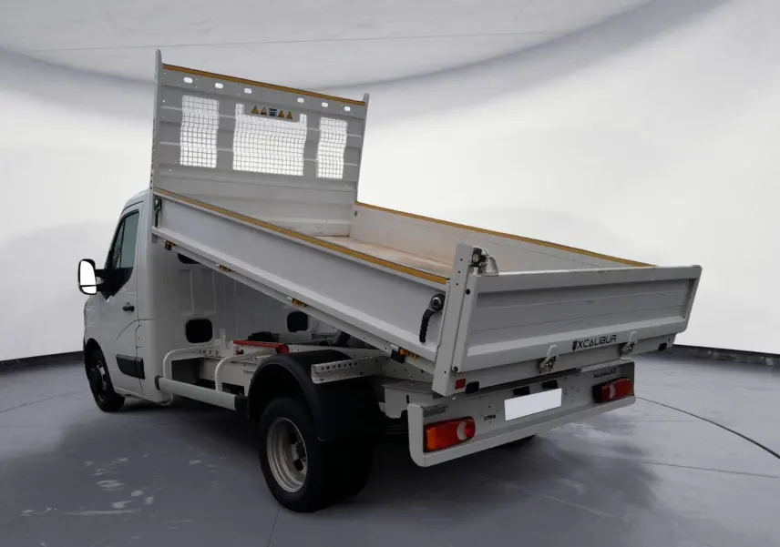 Vue 3/4 arrière droite du Renault Master blanc 2024 avec benne basculante relevée et cabine simple.