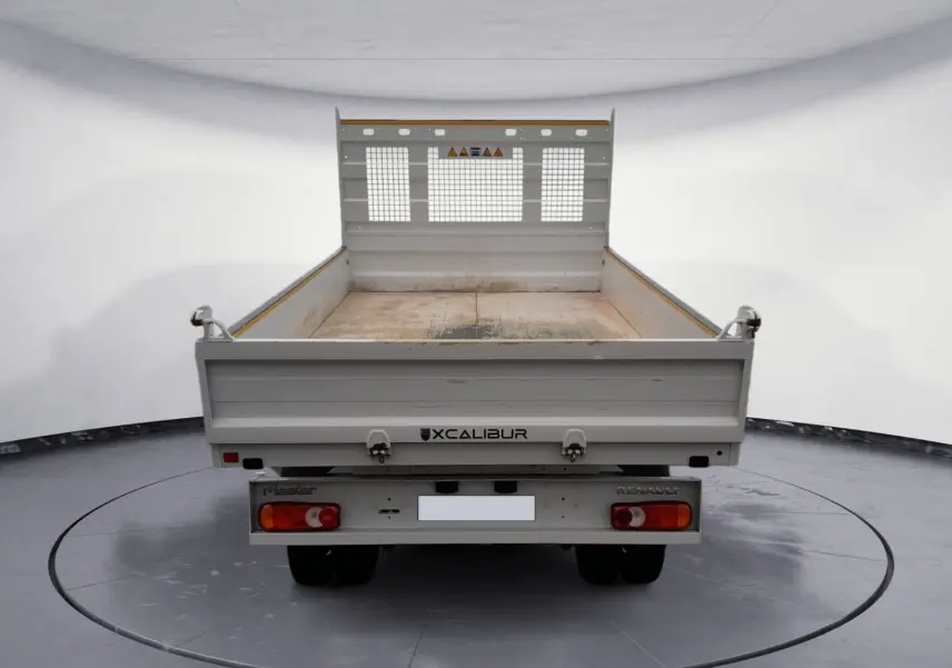 Vue arrière d'une benne blanche Renault Master 2024 avec plateau ouvert et grille de protection métallique.