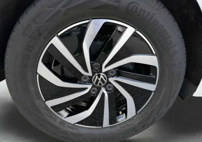 Gros plan sur la jante alliage bicolore noire et argent de la Volkswagen Polo blanche de 2025.