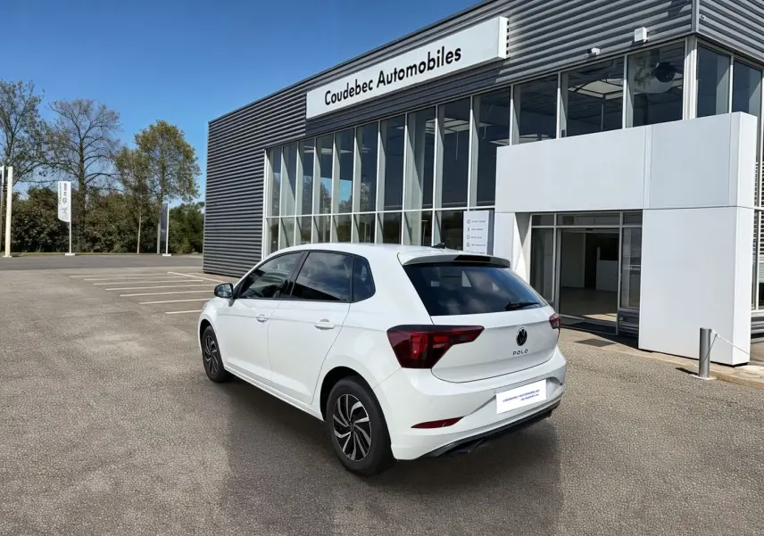 Vue 3/4 arrière droite d'une Volkswagen Polo blanche 2025 stationnée devant un concessionnaire Coudebec Automobiles.