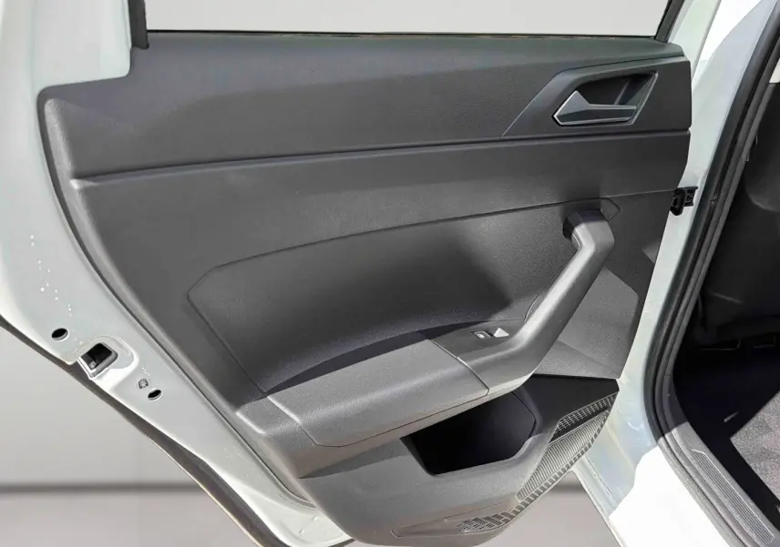 Vue rapprochée de la porte arrière gauche blanche d'une Volkswagen Polo 2025 avec garniture intérieure noire et commandes de vitre.