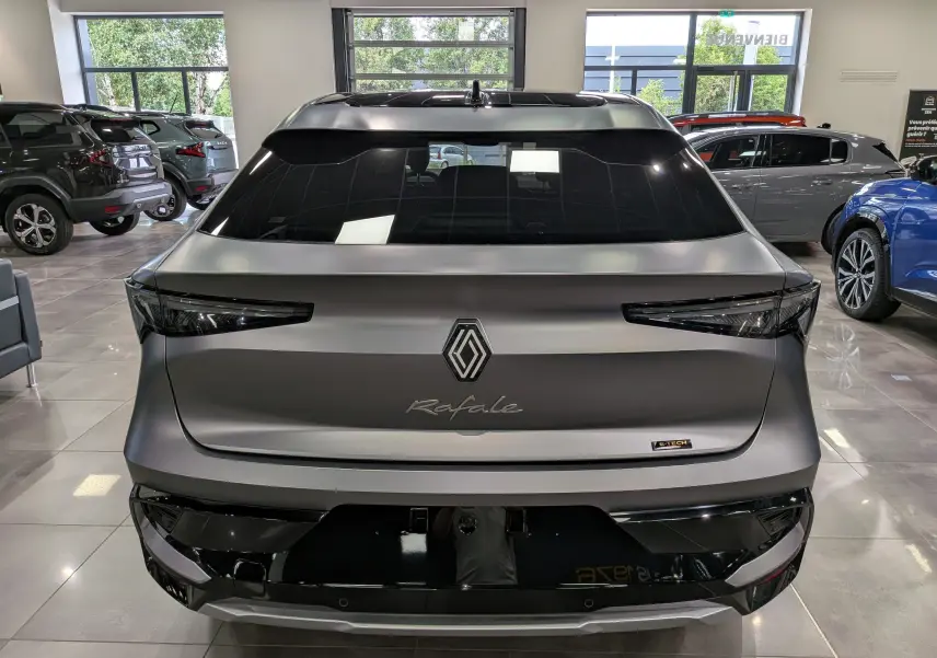 Vue arrière d’un Renault Rafale gris schiste satin avec logo central et feux arrière étirés en intérieur de showroom.