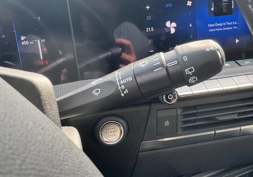 Gros plan intérieur sur la commande d’essuie-glace et bouton start/stop de l’Opel Astra gris 2024, tableau de bord numérique.