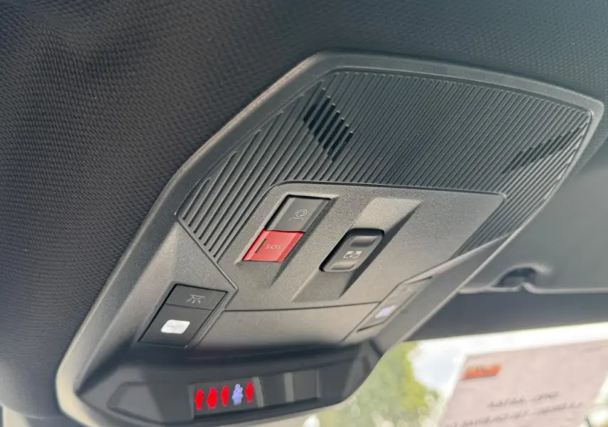 Vue en gros plan du plafonnier gris de l’Opel Astra 2024 avec boutons SOS et éclairage intégré.