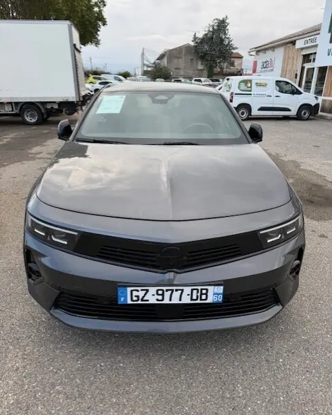 Vue avant d'une Opel Astra gris métallisé 2024 avec calandre noire et plaques d'immatriculation françaises.
