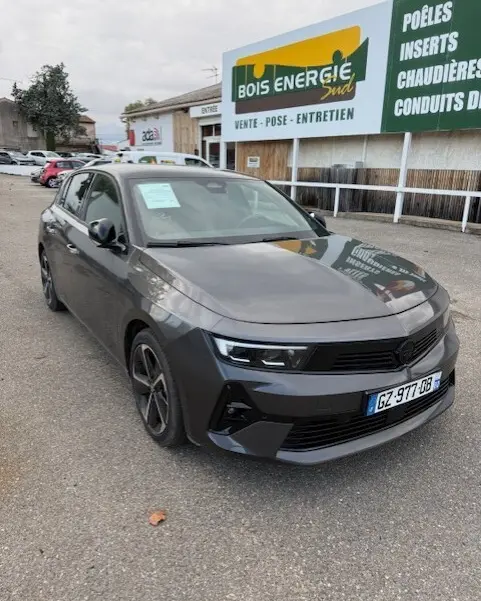 Opel Astra 1.5 Diesel gris 2024 vue 3/4 avant droit, avec calandre noire et jantes alliage sombres.