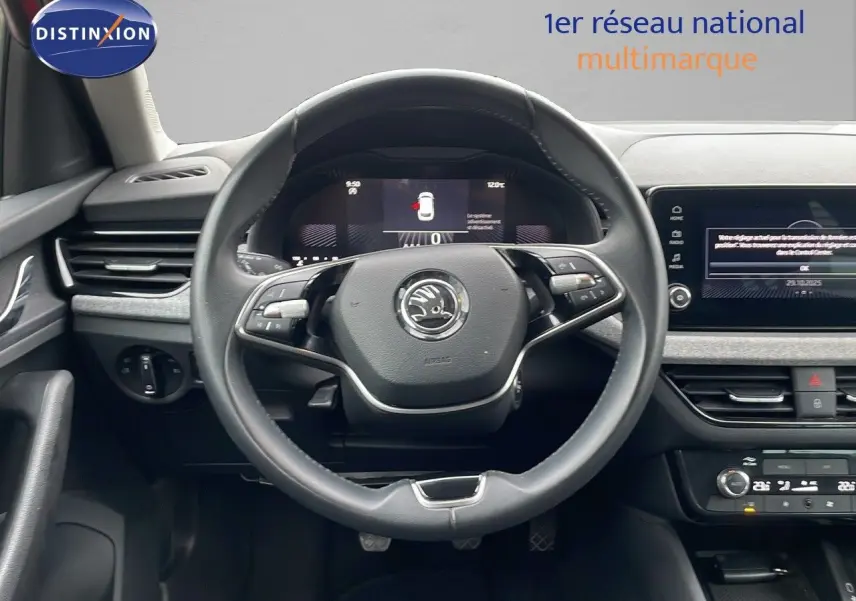 Vue centrée du volant et tableau de bord d'une Skoda Kamiq 2024, intérieur noir avec écran tactile et commandes au volant.