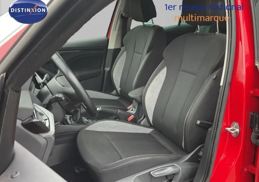 Vue intérieure côté conducteur d'un Skoda Kamiq rouge velvet metal, sièges tissu gris et noir avec coutures apparentes.