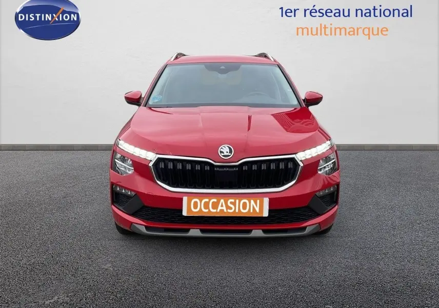 Vue avant d'un Skoda Kamiq rouge Velvet Metal avec calandre noire et feux LED allumés sur fond neutre.