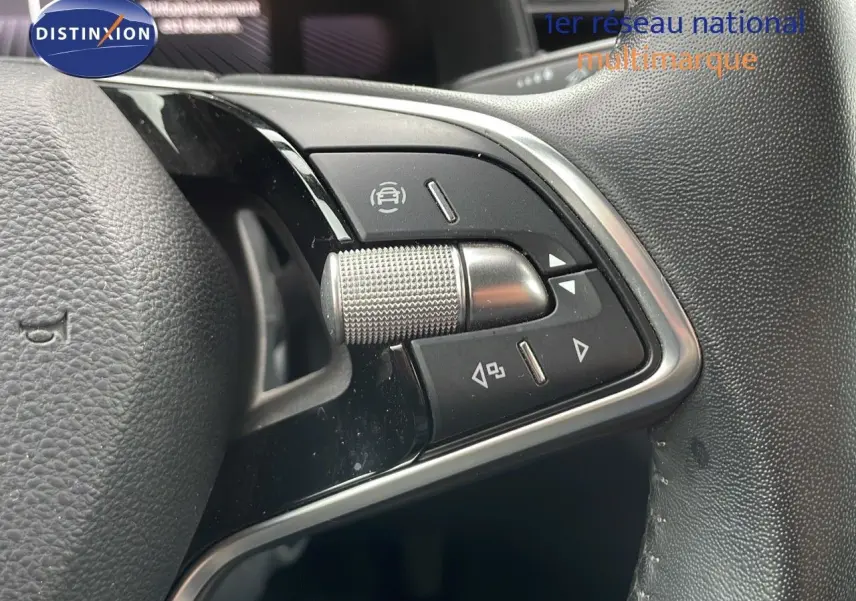 Gros plan sur les commandes multifonctions côté gauche du volant du Skoda Kamiq rouge Velvet Metal 2024.