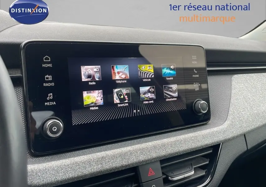 Tableau de bord du Skoda Kamiq 2024 avec écran tactile central et finition tissu gris noir, vue intérieure frontale.