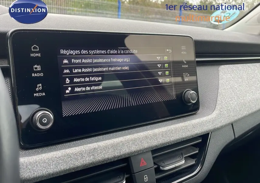 Écran tactile central du Skoda Kamiq 2024 affichant les réglages d'aide à la conduite, avec tableau de bord gris texturé.