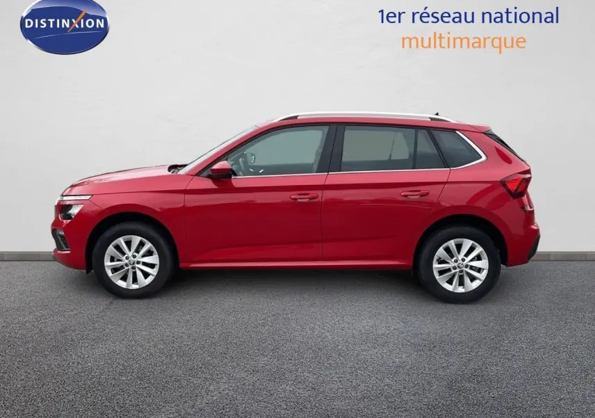 Profil droit d'un Skoda Kamiq 2024 rouge Velvet Metal, compact et moderne, sur fond neutre intérieur showroom.