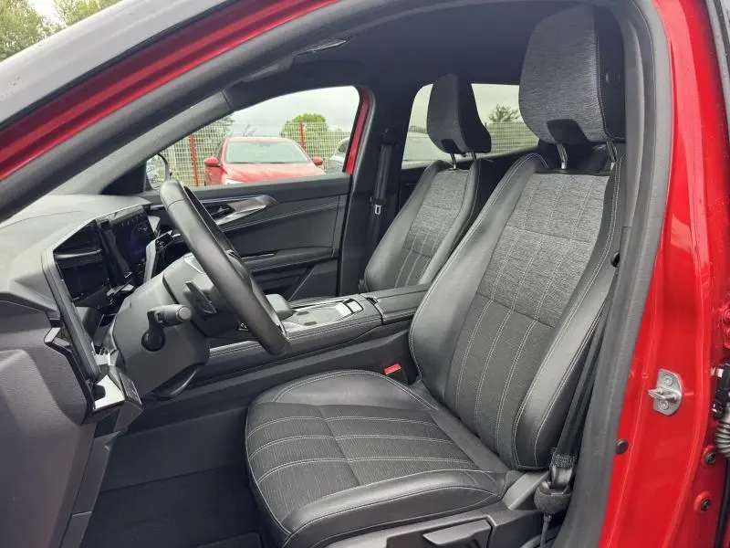 Vue intérieure côté conducteur du Renault Austral rouge, sièges en similicuir/tissu gris dégradé avec volant multifonction.