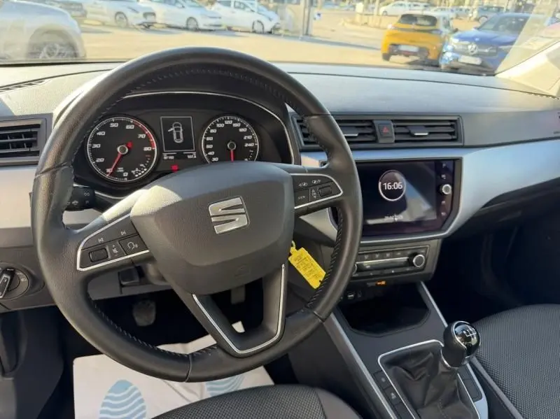 Vue intérieure du poste de conduite du SEAT Arona rouge métal 2019, avec volant multifonction et boîte manuelle.