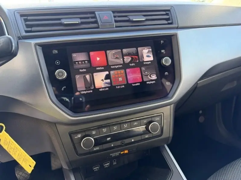 Vue rapprochée de la console centrale du SEAT Arona 2019, écran tactile et commandes climatisation visibles.