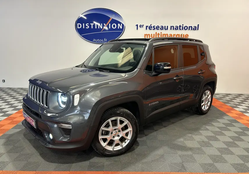 Jeep Renegade gris graphite en 3/4 avant droit, avec toit ouvrant et jantes argentées visibles en intérieur showroom.