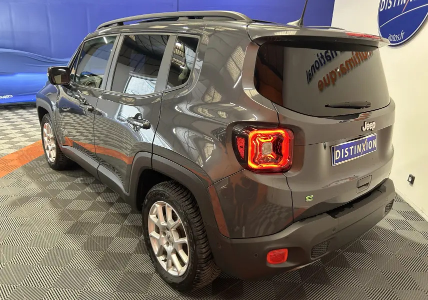 Vue 3/4 arrière droite du Jeep Renegade gris graphite 2023 avec feux arrière allumés et toit ouvrant fermé.