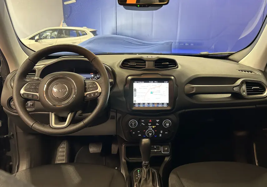 Vue intérieure frontale du tableau de bord du Jeep Renegade 2023 avec écran tactile et volant multifonctions en cuir.