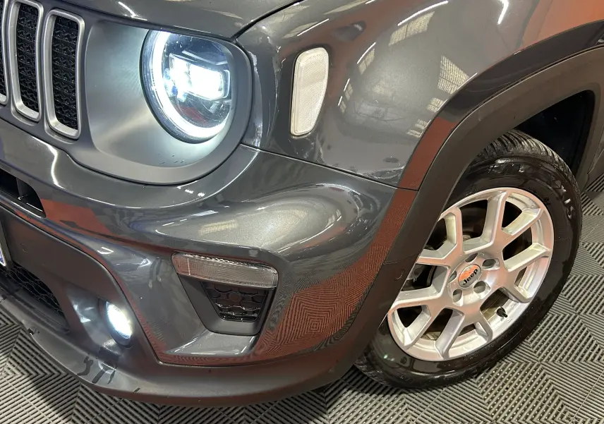 Gros plan sur l'avant droit du Jeep Renegade gris graphite 2023, mettant en valeur le phare LED allumé et la jante alu.