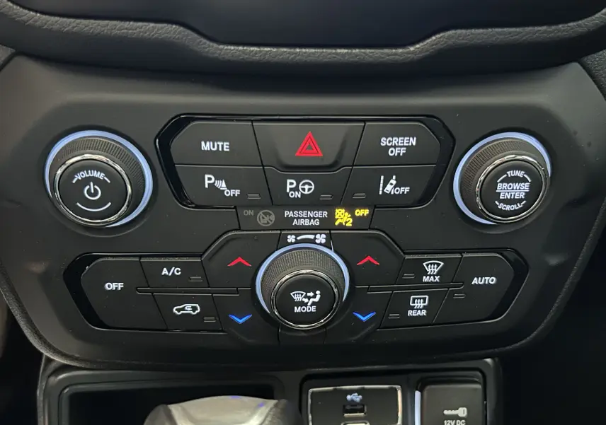Vue rapprochée du tableau de bord central du Jeep Renegade 2023, avec commandes climatisation et audio en noir mat.