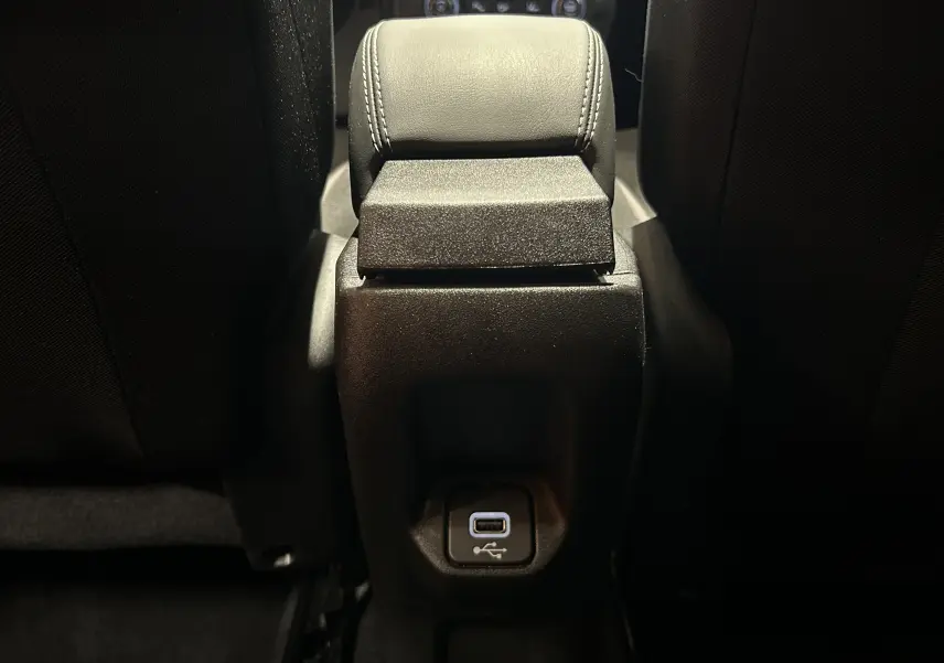 Vue rapprochée de la console centrale arrière avec accoudoir en cuir noir et port USB du Jeep Renegade 2023 gris graphite.