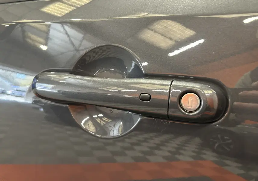 Gros plan sur la poignée de porte côté gauche gris graphite d’une Jeep Renegade 2023 avec serrure intégrée.