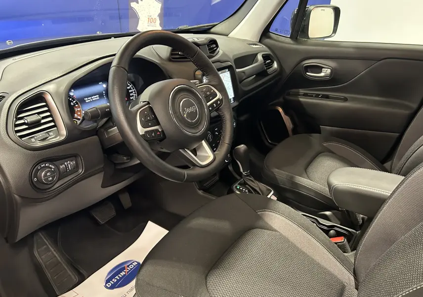 Vue intérieure côté conducteur du Jeep Renegade 2023, tableau de bord et sièges noirs avec volant multifonction.