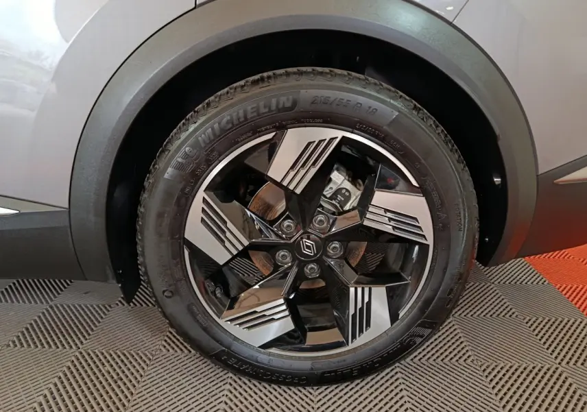 Gros plan sur la roue avant droite grise du Renault Symbioz avec jante noire et argent au design géométrique.