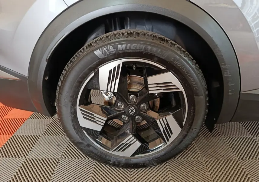 Gros plan sur la roue avant droite argentée du Renault Symbioz avec jante noire et argentée au design moderne.