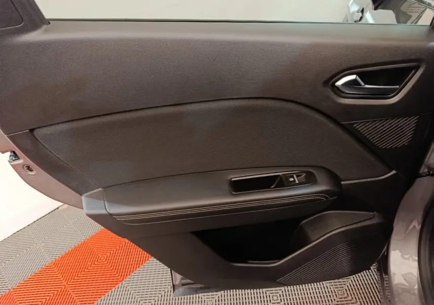 Vue intérieure de la porte avant droite noire du Renault Symbioz Iconic E-Tech 2025 avec commande de fenêtre.