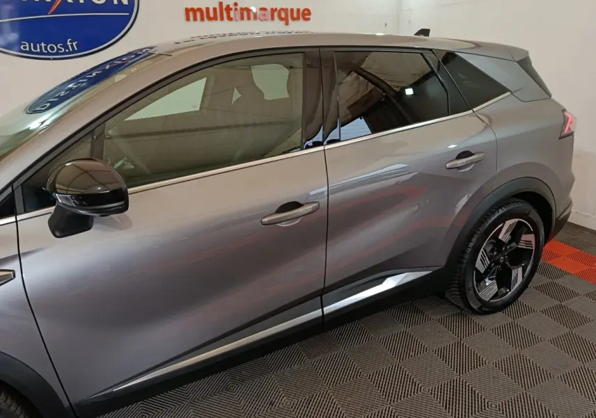 Vue latérale droite du Renault SYMBIOZ gris métallisé avec jantes noires et toit contrasté dans un showroom.