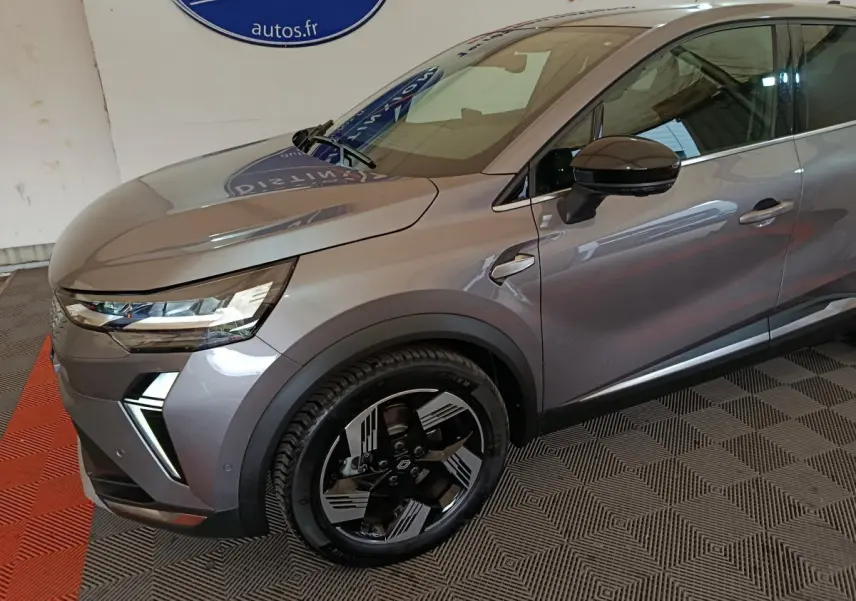 Vue 3/4 avant droit d'une Renault SYMBIOZ gris métallisé avec phares LED et jantes noires au design futuriste.