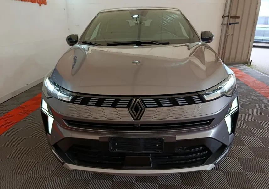 Vue frontale d'une Renault SYMBIOZ gris clair avec feux LED allumés et calandre au design moderne.