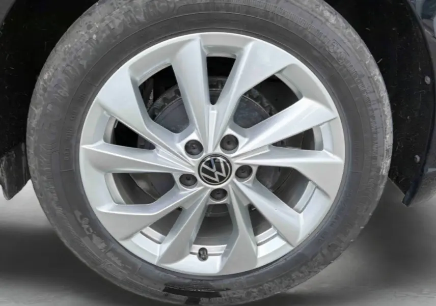 Gros plan sur la jante alliage 16'' Palermo argentée d'une Volkswagen Polo noire, avec logo VW central visible.
