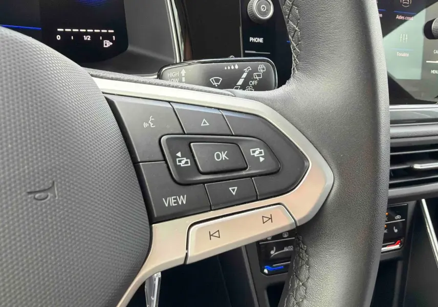 Gros plan sur le volant cuir noir multifonctions côté gauche du Volkswagen Polo 2025 avec commandes intégrées.
