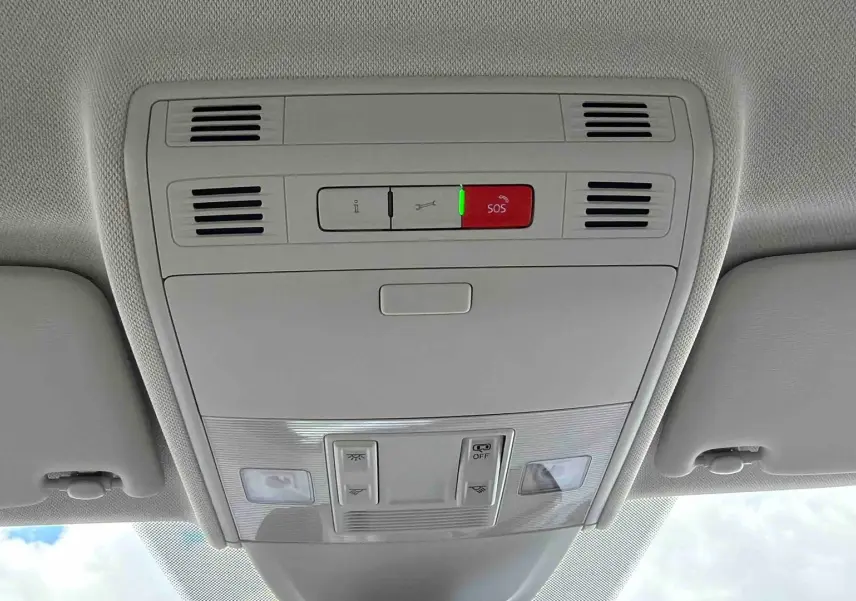 Vue intérieure du plafonnier gris clair avec boutons de commande et alerte SOS allumée dans une Volkswagen Polo noire.