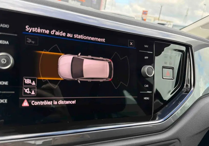 Écran tactile intérieur montrant l’aide au stationnement de la Volkswagen Polo 2025, détails en noir brillant.